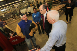 Third-year sheet metal apprentice Gregory Leonard, left, speaks with Thomas Perez, U.S. Secretary of Labor, center, and John Healy, training coordinator for Sheet Metal Workers Local No. 17, during a tour of the facility and round-table discussion on Nov. 17, 2014.