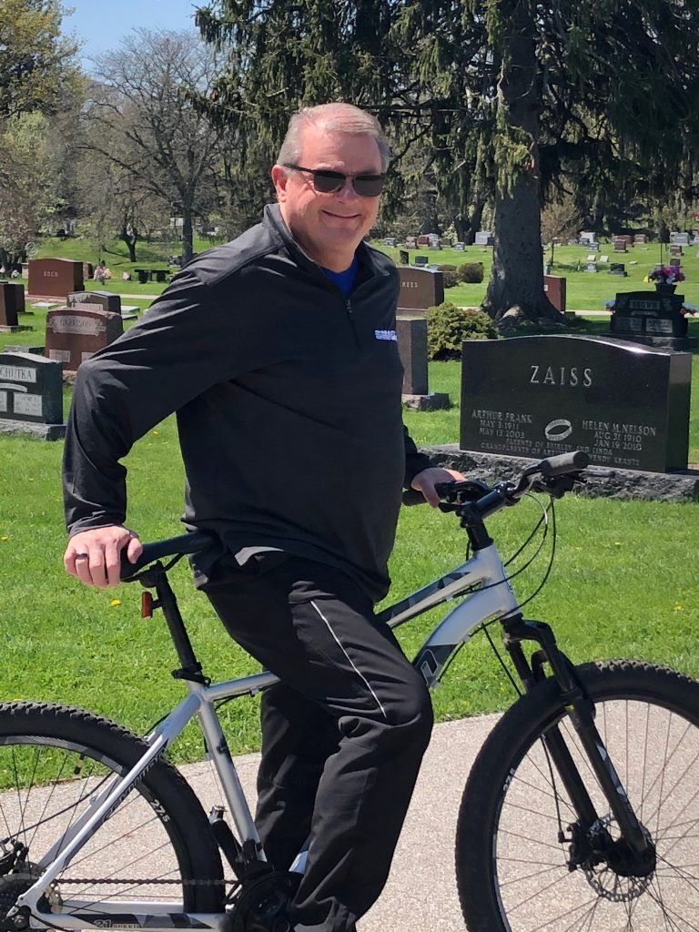 Charles Jon Garst standing with a bike