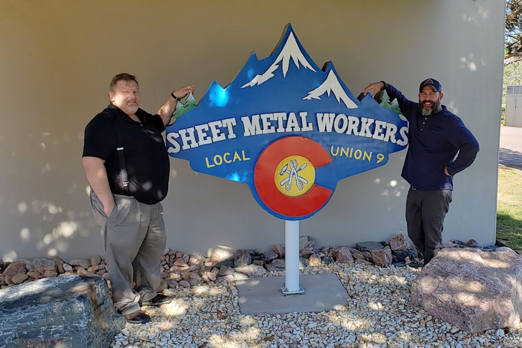 Andy Gillilard and Greg Daniels posing next to Local 9 sign.
