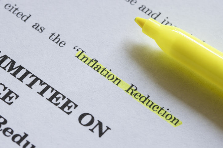 A yellow highlighter and a closeup of the documents of the Inflation Reduction Act with the words "Inflation Reduction" highlighted